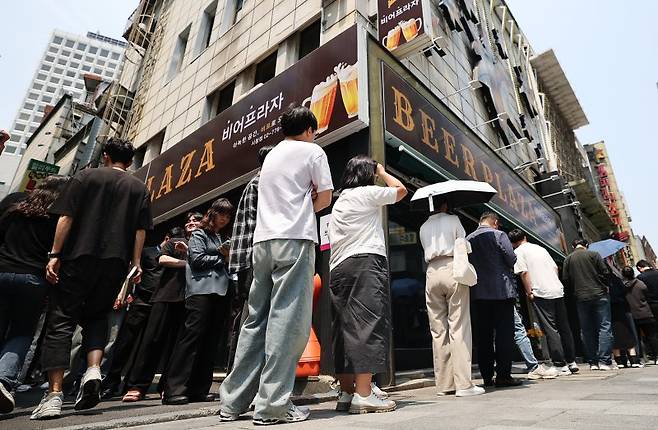 지난 29일 서울 중구 소공동주민센터에 마련된 투표소에서 직장인들이 사전투표를 하기 위해 길게 줄을 서고 있다. 뉴스1