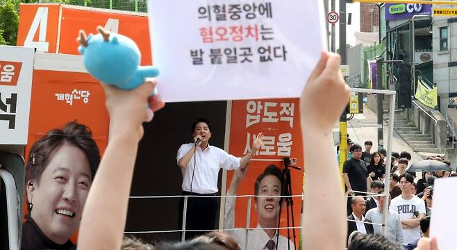 30일 오후 서울 동작구 중앙대학교 후문에서 대학생들이 유세를 펼치는 이준석 개혁신당 대선후보를 향해 혐오 발언 규탄 피켓을 들어 보이고 있다. 뉴시스