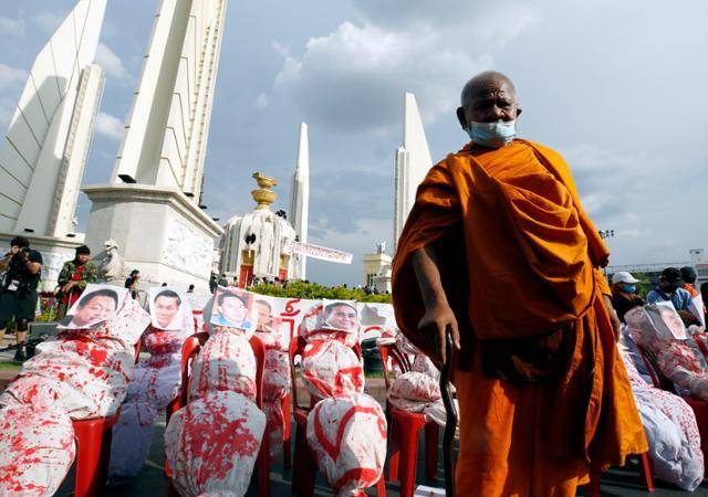 2021년 8월 태국 방콕 민주기념비 앞에서 열린 반정부 시위에서 한 승려가 쿠데타 군부 내각 인사들의 사진이 붙은 인형을 배경으로 서 있다. 방콕=EPA 연합뉴스