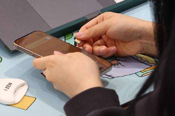 SK텔레콤이 유심(USIM) 무료 교체 서비스를 시작한 지난달 28일 서울 시내 한 SKT 대리점에서 직원이 유심 교체를 진행하고 있다. [사진=연합뉴스]