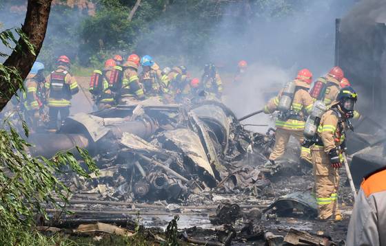 지난 29일 오후 1시 50분께 경북 포항시 남구 동해면 신정리 한 야산에 해군 초계기가 추락한 가운데 소방관들이 화재 진압을 하고 있다. 연합뉴스