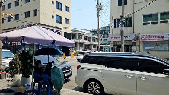 30일 서울 영등포구의 한 사전투표소 앞에서 그늘막을 설치한 남녀 2명이 '선거 감시' 명목으로 사전투표소를 오가는 유권자를 촬영했다. 이들은 ″사전투표가 조작됐다고 의심된다″고 주장했다. 이찬규 기자