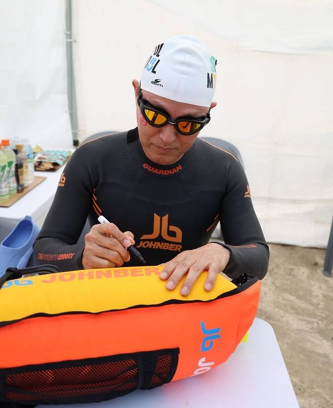 쉬엄쉬엄 한강 3종 축제’ 1일차 수영종목 출발에 앞서 안전부이에 ‘수영하기 너무 좋은 한강으로 오세요, 수질 환상적!’ 문구를 쓰고 있다. [서울시 제공]