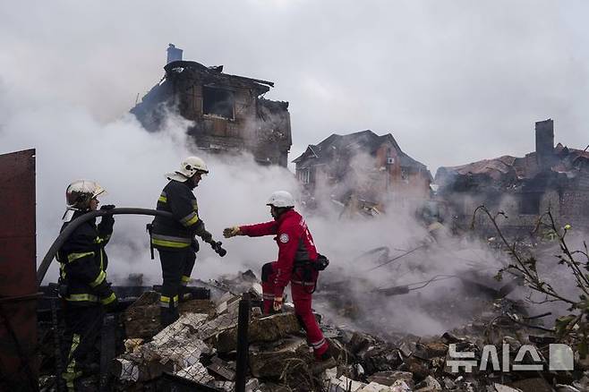 [키이우=AP/뉴시스]25일(현지 시간) 우크라이나 키이우 마르할리우카에서 구조대원들이 러시아의 공습으로 파괴된 주택에서 발생한 화재를 진압하고 있다. 러시아군의 여름 대공세가 시작됐다. 2025.05.30.