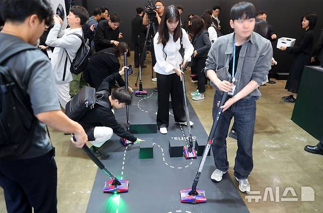 [서울=뉴시스] 김혜진 기자 = 26일 오전 서울 성동구 무신사스퀘어성수4에서 열린 다이슨 신제품 청소기 '펜슬백' 공개 행사에서 관계자들이 제품을 체험하고 있다. 2025.05.26. jini@newsis.com