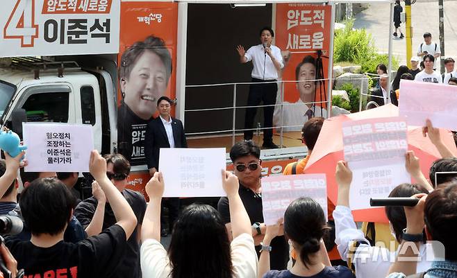 [서울=뉴시스] 추상철 기자 = 30일 오후 서울 동작구 중앙대학교 후문에서 대학생들이 유세를 펼치는 이준석 개혁신당 대선후보를 향해 혐오 발언 규탄 피켓을 들어 보이고 있다. 2025.05.30. scchoo@newsis.com