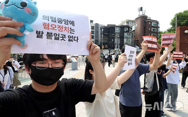 [서울=뉴시스] 추상철 기자 = 30일 오후 서울 동작구 중앙대학교 후문에서 대학생들이 유세를 펼치는 이준석 개혁신당 대선후보를 향해 혐오 발언 규탄 피켓을 들어 보이고 있다. 2025.05.30. scchoo@newsis.com