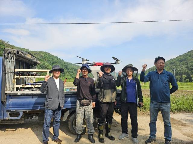 이병길 여주농협 조합장(맨 왼쪽)이 드론을 활용한 벼 중기제초제 입제 살포에 앞서 작업자들을 격려하고 있다.