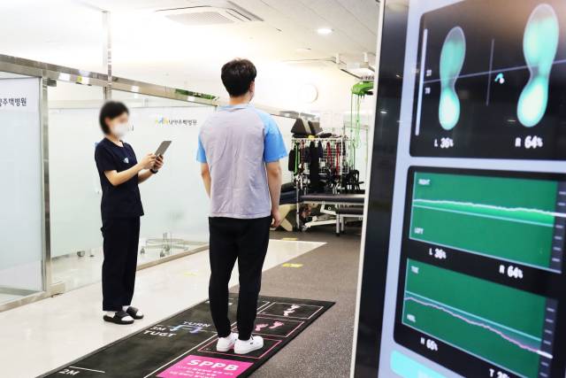 남양주백병원에서 수술을 받은 환자(오른쪽)가 물리치료사의 안내에 따라 인공지능(AI) 보행분석 솔루션을 활용한 검사를 받고 있다. 사진 제공=남양주백병원