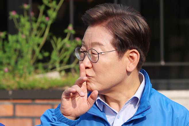 이재명 더불어민주당 대선 후보가 30일 강원도 원주시 반곡동 원주행복마당에서 유세를 마친 뒤 취재진과 질의응답을 하던 중 이 후보를 응원하는 지지자들을 향해 잠시 조용해달라는 의미로 손가락을 입에 대고 있다. ⓒ연합뉴스