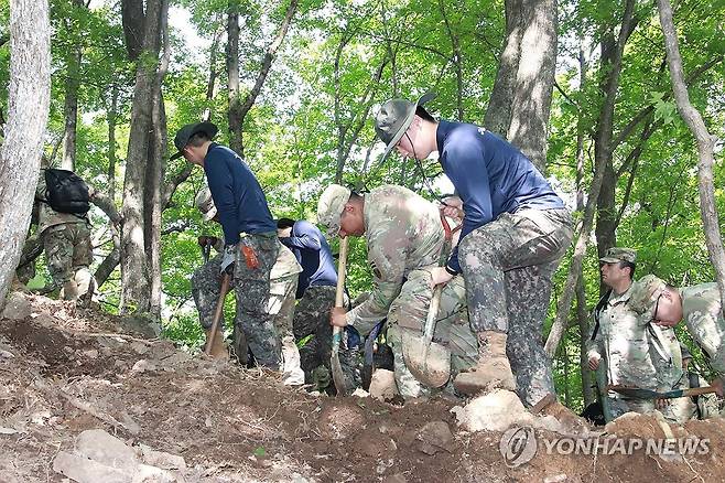 유해발굴 함께 하는 한미 장병 (가평=연합뉴스) 육군 수도기계화보병사단은 지난 22일 경기도 가평군 호명산 6·25 전사자 유해발굴지역에서 자매결연 미군부대 초청행사를 진행했다. 이날 미2사단/한미연합사단 95화생방중대 장병들은 호명산에서 우리 군과 함께 유해발굴작전에 참여했다. 사진은 한미장병들이 유해발굴 작업을 하는 모습. 2025.5.23 [육군 수도기계화보병사단 제공. 재판매 및 DB 금지] andphotodo@yna.co.kr