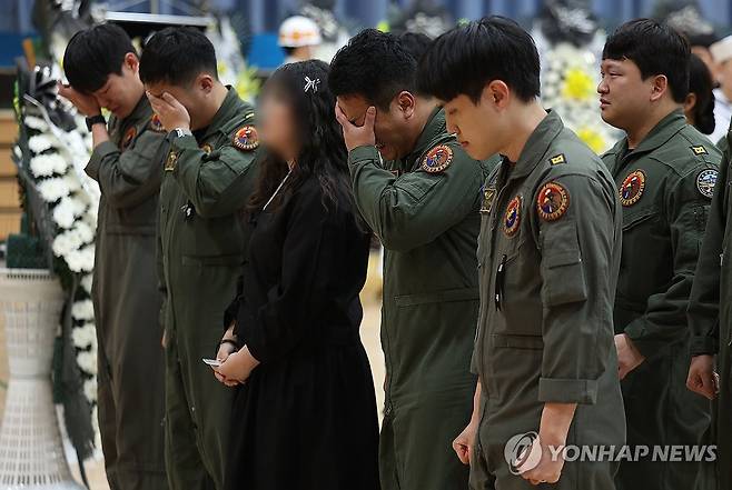 순직 해군 영정 앞에 선 유족과 동료들 (포항=연합뉴스) 윤관식 기자 = 30일 경북 포항시 남구 해군 항공사령부 체육관에 마련된 '해군 P-3CK 917호기 순직자 합동분향소'에서 순직 해군의 유족과 동료들이 영정 앞에서 슬퍼하고 있다. 2025.5.30 psik@yna.co.kr