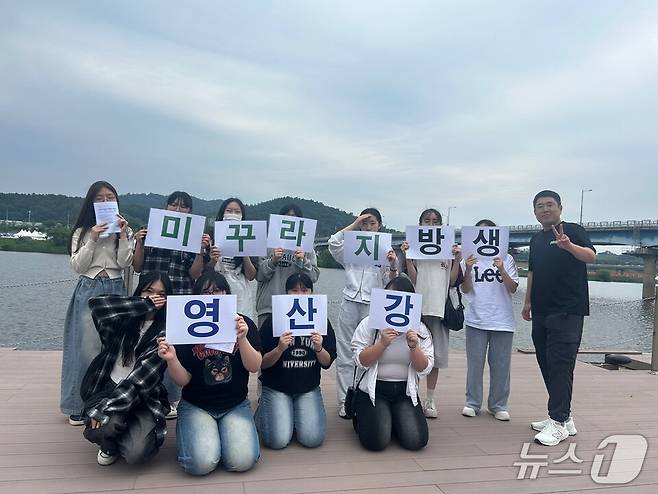 환경동아리 학생들이 영산강에 미꾸라지를 방생한 후 기념사진을 찍고 있다. (전남도교육청 제공, 재판매 및 DB 금지)