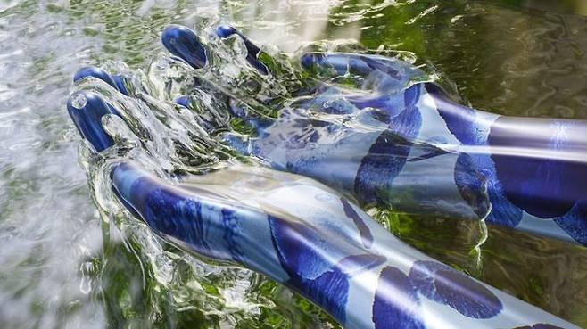 흐르는 개울물을 로봇의 양손이 퍼담는 모습. 게티이미지뱅크