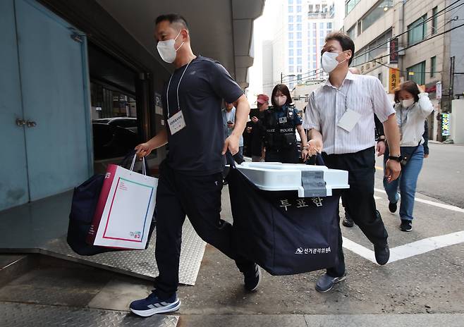 제21대 대통령선거 사전투표 마지막 날인 30일 오후 서울 중구에 위치한 중구선거관리위원회에서 관계자들이 관내 사전투표함을 보관장소에 이송하고 있다. /뉴시스