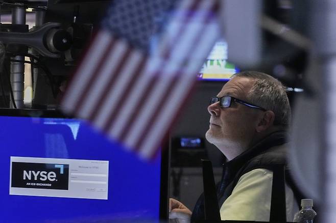 트레이더 마이클 콘론이 지난 12일 미국 뉴욕증권거래소에서 등락중인 수치에 눈을 떼지 못한 채 살펴보고 있다.  AP 뉴시스