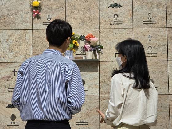 최원종에게 희생된 고 김혜빈(사망 당시 20세)씨의 아버지(왼쪽)와 어머니(오른쪽)가 경기 성남시 야탑동 분당메모리얼파크 봉안당에서 딸의 영정 앞에 생전 즐겼던 커피와 쿠키를 놓아주고 있다. 손성배 기자