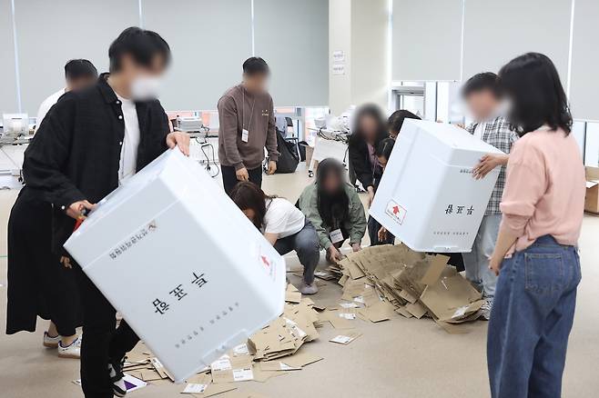 30일 서울 중구 을지누리센터에 마련된 사전투표소에서 사전투표사무원들이 참관인 및 공정선거참관단이 지켜보는 가운데 관외투표함을 열고 있다. 사진 연합뉴스