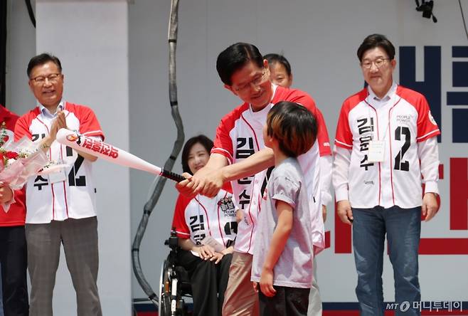 [속초=뉴시스] 고승민 기자 = 김문수 국민의힘 대선 후보가 31일 강원 속초 관광수산시장에서 유세를 하기 전 선물받은 '역전홈런'이라고 쓰여진 야구 배트를 휘두르는 포즈를 취하고 있다. 2025.05.31. kkssmm99@newsis.com /사진=고승민