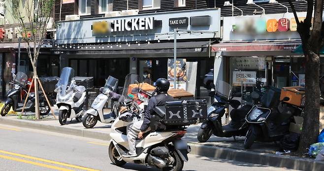 서울 시내 한 음식점 앞으로 배달 라이더가 지나가고 있다. [연합]