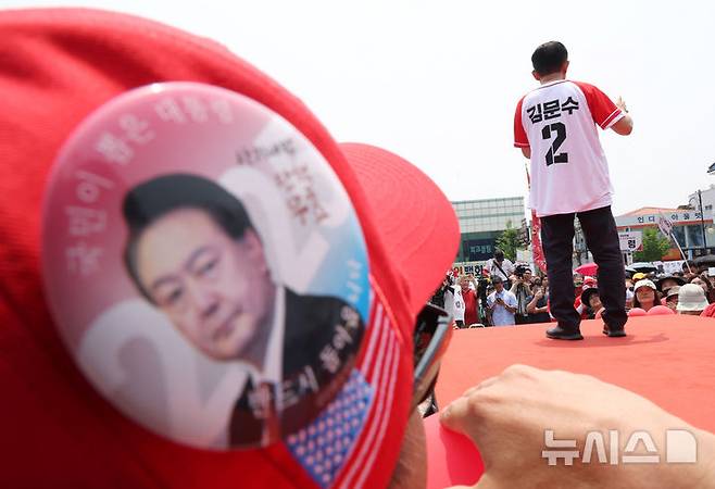 [김해=뉴시스] 고승민 기자 = 김문수 국민의힘 대선 후보가 28일 경남 김해수로왕릉 공원에서 유세를 하고 있다. 어느 윤석열 전 대통령 지지자가 이를 가까이서 지켜보고 있다. 2025.05.28. kkssmm99@newsis.com