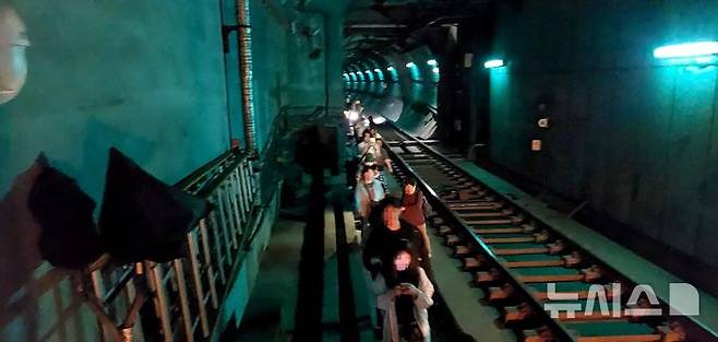 [서울=뉴시스] 31일 오전 서울 지하철 5호선 여의나루~마포역 구간에서 방화로 인한 화재가 발생한 가운데 승객들이 열차에서 내려 선로를 따라 대피하고 있다. (사진=영등포소방서 제공)