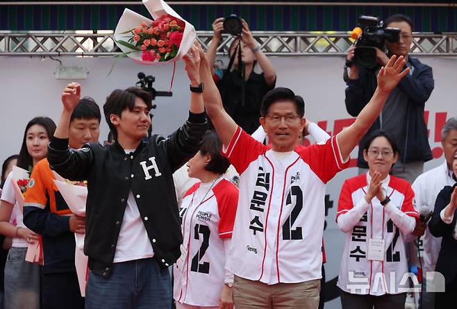 [포항=뉴시스] 고승민 기자 = 김문수 국민의힘 대선 후보가 31일 경북 포항 북포항우체국 앞에서 청년 지지자에게 꽃다발을 받은 뒤 포즈를 취하고 있다. 2025.05.31. kkssmm99@newsis.com