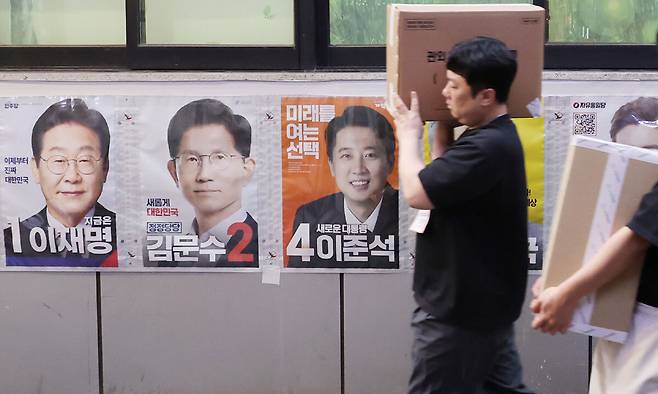 제21대 대통령선거 사전투표 둘째 날인 30일 서울 중구 소공동주민센터에 마련된 사전투표소에서 사전투표사무원들이 관내 사전투표함과 관외 사전투표지를 이송하고 있다. 연합뉴스