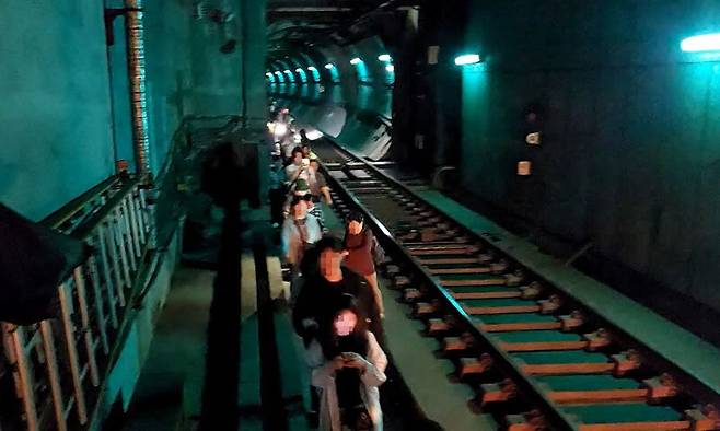 31일 오전 서울 지하철 5호선 여의나루~마포역 구간에서 방화로 인한 화재가 발생한 가운데 승객들이 열차에서 내려 선로를 따라 대피하고 있다. 영등포소방서 제공