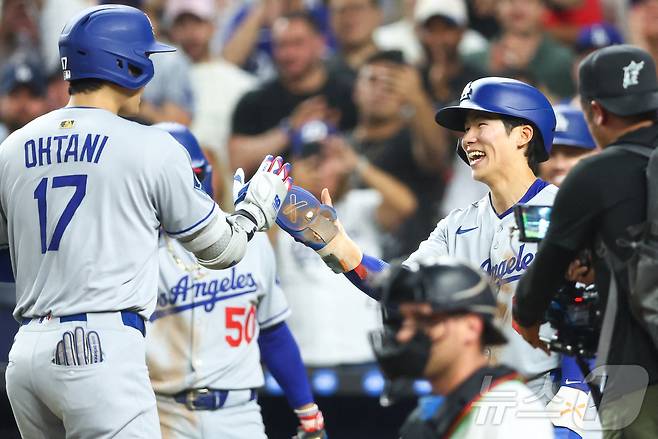 김혜성(로스앤젤레스 다저스)이  지난달  6일(한국시간) 미국 플로리다주 마이애미 론디포 파크에서 열린 2025 미국프로야구 메이저리그(MLB) 마이애미 말린스와의 경기에서 오타니 쇼헤이의 홈런으로 득점한 뒤 하이파이브를 하고 있다. 이날 김혜성은 데뷔 첫 안타를 포함, 4타수 2안타 1타점 1득점 1도루를 기록했다. ⓒ AFP=뉴스1