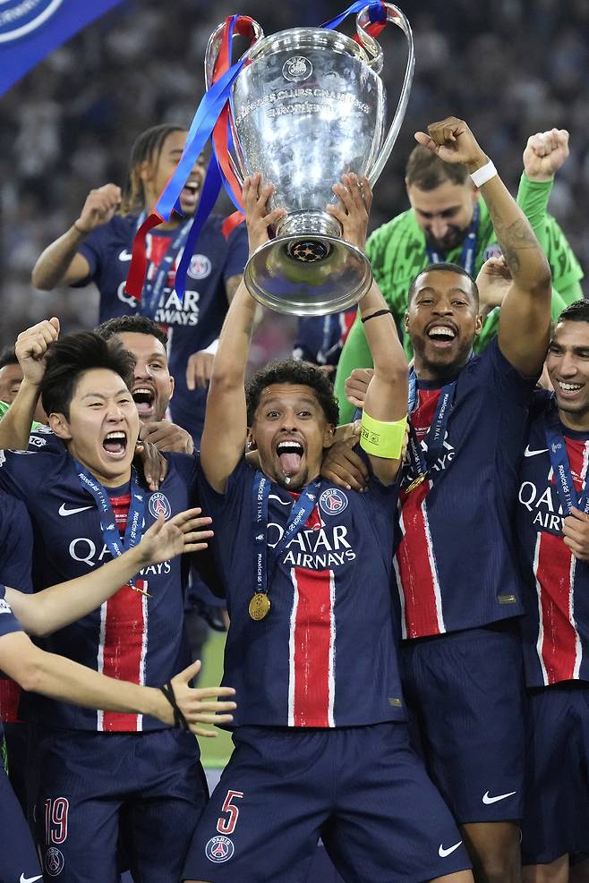 PSG 이강인(왼쪽)이 빅이어를 들어 올리는 주장 마르퀴뇨스 옆에 자리 잡았다. [AP=연합뉴스]