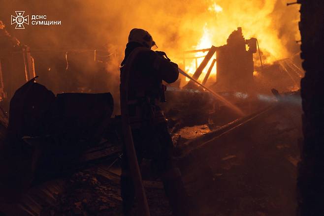 러시아가 우크라이나 수미주에 대한 공격을 감행한 29일(현지시간) 밤 한 소방관이 진압에 나서고 있다. 로이터연합뉴스