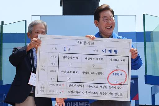 더불어민주당 이재명 대선 후보가 선거를 이틀 앞두고 ‘험지 공략’에 나선 1일 고향인 경북 안동시의 웅부공원에서 열린 유세에서 초등학교 은사인 박병기 선생님으로부터 대선 후보 모의 성적통지표를 받고 있다. 연합뉴스