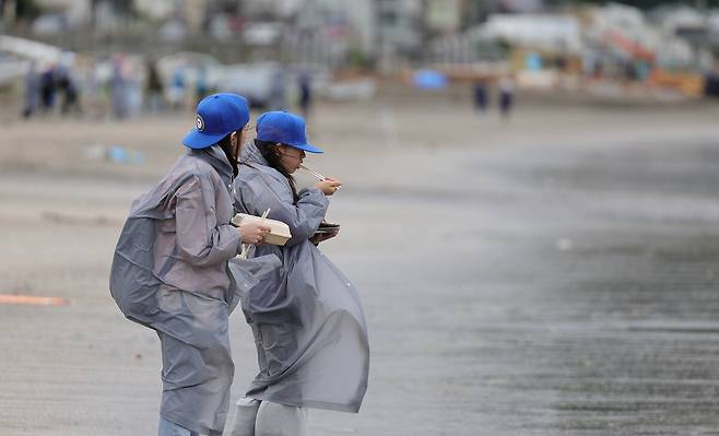 지난달 31일 일본 카나가와현 가마쿠라시 에노시마섬 자이모쿠자 해변에서 열린 '2025 세계드론낚시대회 in Japan'에서 한 가족이 낚시줄을 보며 도시락을 먹고 있다.&nbsp; 가마쿠라=이재문 기자