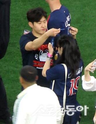 PSG 이강인(왼쪽)이 1일(한국시간) 독일 뮌헨 알리안츠 아레나에서 열린 UCL 우승 행사 도중 연인 박상효 씨에게 우승 메달을 직접 걸어주고 있다. 뮌헨(독일)｜남장현 기자