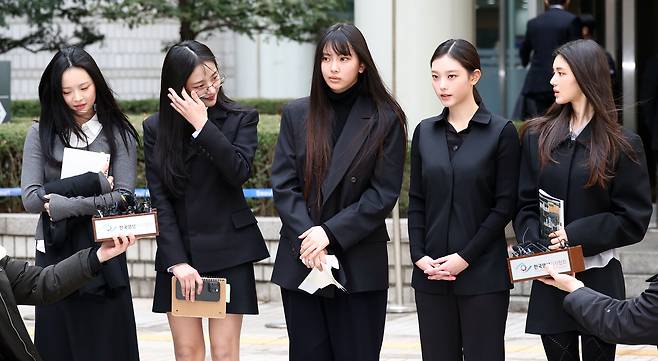 그룹 뉴진스가 지난 3월 7일 서울 서초구 서울중앙지방법원에서 열린 ‘기획사 지위보전 및 광고계약 체결 등 금지’ 가처분 신청의 심문기일을 마친 뒤 법원 청사를 나서며 취재진 질문에 답하고 있다. 왼쪽부터 하니, 민지, 혜인, 해린, 다니엘. 연합뉴스