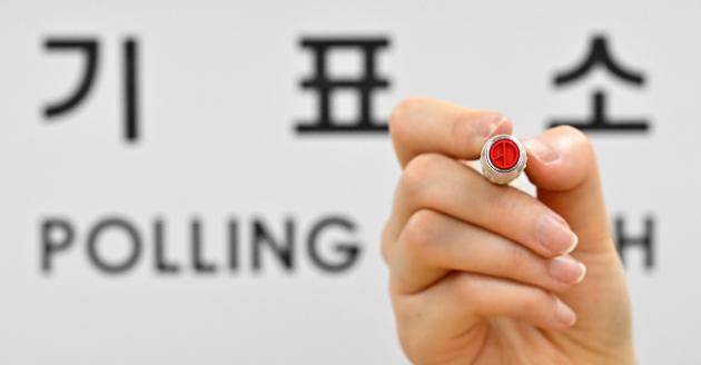 제21대 대통령 선거를 하루 앞둔 2일 서울 용산구 청파도서관에 마련된 청파동 제1투표소에서 관계자가 기표 도장을 들어 보이고 있다. <공동취재단>