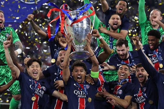 PSG 이강인(왼쪽)이 동료들과 함께 UCL 트로피를 들어 올리고 있다. 사진=AFPBB NEWS