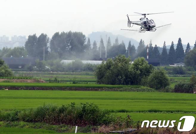 25일 서울 강서구 과해동 '서울 경복궁 쌀' 재배집단지역에서 친환경농약을 실은 헬기가 벼 병해충 항공방제 작업을 하고 있다. 2018.7.25/뉴스1 ⓒ News1 송원영 기자