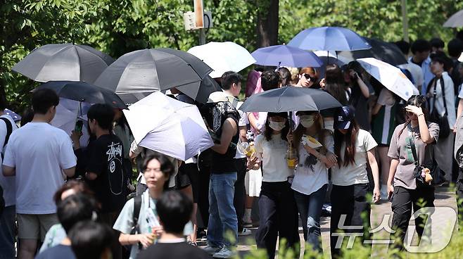 전국적으로 초여름 날씨를 보인 22일 서울 광진구 건국대학교에서 학생들이 우산과 양산으로 햇빛을 가린 채 노천극장 입장을 기다리고 있다. 2025.5.22/뉴스1 ⓒ News1 김성진 기자