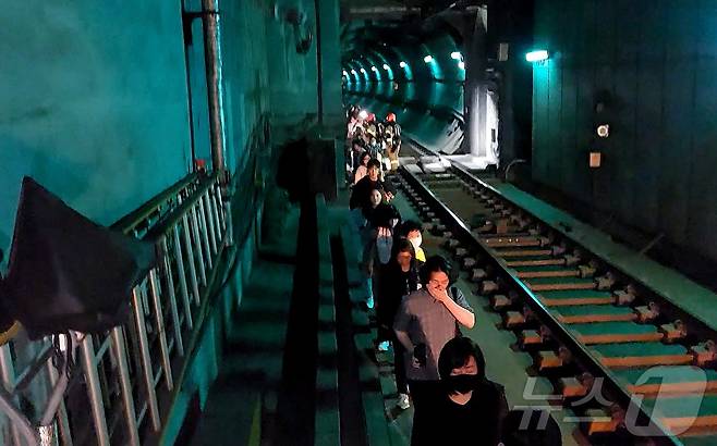 31일 오전 서울 지하철 5호선 마포역~여의나루역 구간을 지나는 열차에서 방화로 인한 화재가 발생, 승객들이 선로를 통해 대피하고 있다. (영등포소방서 제공. 재판매 및 DB 금지) 2025.6.1/뉴스1