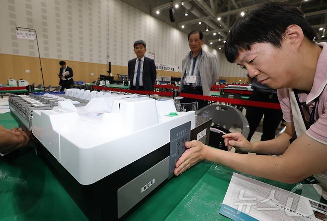 21대 대통령선거를 하루 앞둔 2일 대전 유성구 대전컨벤션센터에 마련된 개표소에서 유성구선관위 관계자들이 개표 준비 상황을 점검한 뒤 투표지 분류기에 봉인지를 부착하고 있다. 2025.6.2/뉴스1 ⓒ News1 김기태 기자