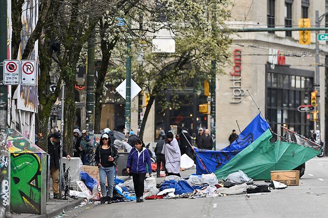 캐나다 밴쿠버 시의 직원들이 2023년 4월 5일 밴쿠버 다운타운 이스트사이드의 이스트 해스팅스 스트리트에 위치한 캠프에 거주하는 사람들의 임시 구조물과 텐트를 철거하고 있다. / 로이터