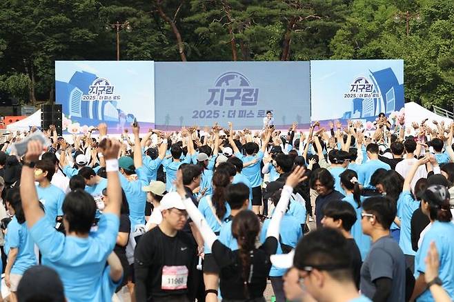 ▲ ‘2025 지구런 : 더 피스 로드’ 참가자들이 출발 전 메인 무대 앞에서 준비운동에 참여하며 뜨거운 열기를 더하고 있다. (사진제공=지구런)