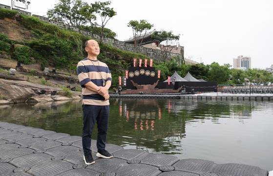 경남 진주에서 51년의 관록을 자랑하는 '극단현장'의 고능석 연출가가 지난달 23일 실경역사뮤지컬 진주 남강 수상현장세트 앞에서 본지와 인터뷰에 앞서 포즈를 취했다. 그가 발딛고 서 있는 게 폰툰(pontoon)으로 원래는 군대의 수상작전에서 물에 띄우는 용도로 쓰이며 이곳에선 수상 특설객석을 받쳐준다. 송봉근 기자