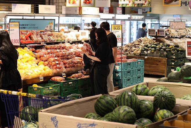 Shoppers look around produce at a large shopping mart in Seoul on May 23. [YONHAP]