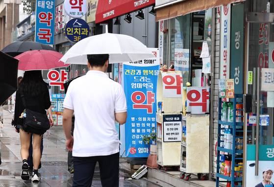 Pedestrians pass by pharmacies and clinics in central Seoul. [NEWS1]