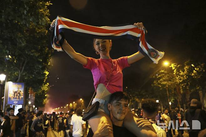 [파리=AP/뉴시스] = 1일(현지 시간) 유럽축구연맹(UEFA) 챔피언스리그(UCL) 결승전에서 파리 생제르맹이 우승을 차지 한 뒤 프랑스 파리 샹젤리제 거리에서 응원단이 기뻐하고 있다. 2025.06.02. photo@newsis.com