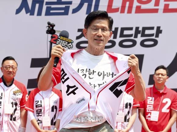 가슴 활짝 편 김문수 - 김문수 국민의힘 대선 후보가 1일 서울 강남구 코엑스에서 열린 유세에서 상의 앞섶을 풀어 헤치며 티셔츠에 적힌 ‘정직한 아버지 깨끗한 대통령’이란 문구를 보여 주고 있다. 안주영 전문기자