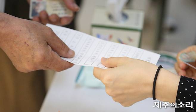 제21대 대통령선거 투표일인 3일 오전 6시 제주시 이도2동에 위치한 제5투표소에서 선거사무원이 유권자에게 투표용지를 배부하고 있다. ⓒ제주의소리